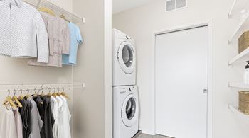Laundry room with clothes hanging up and washing machine
